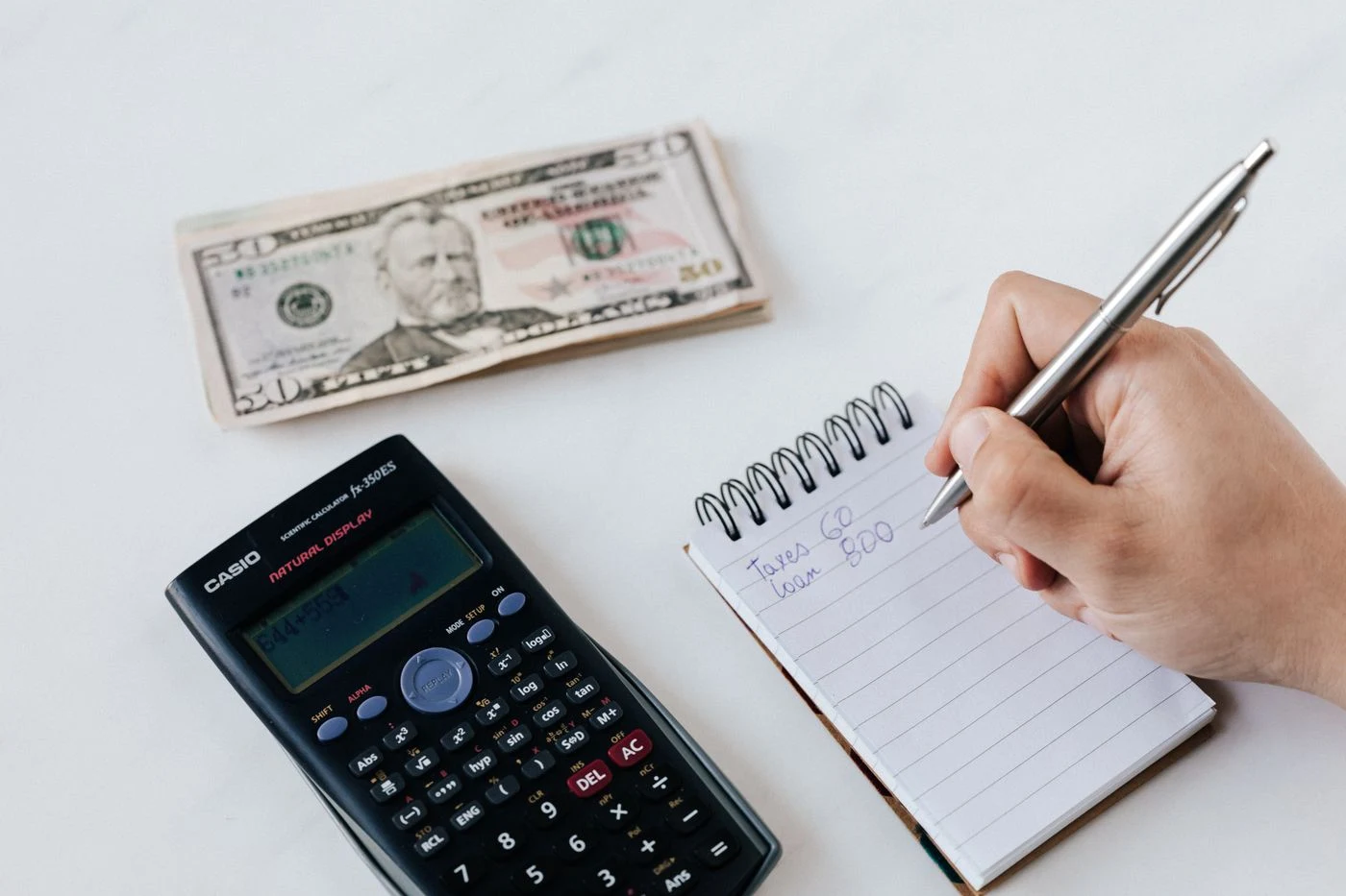 Bookkeeping with a calculator and handwritten ledger notes